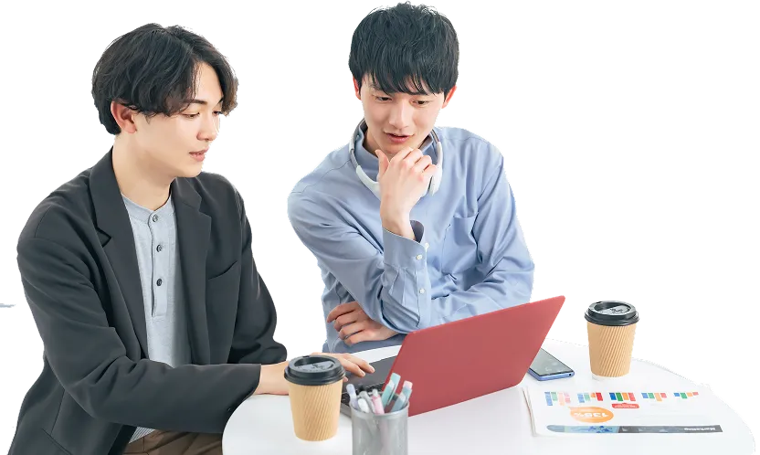 パソコンの前で会話する二人の男性