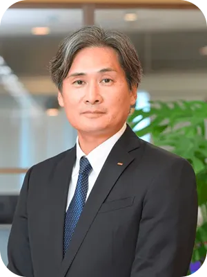 カウンセラースーツを着用した、落ち着いた表情の男性スタッフ