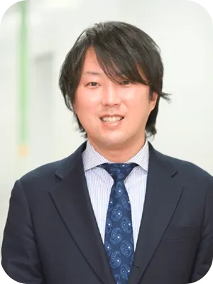 スーツを着用し、穏やかに微笑む男性スタッフ